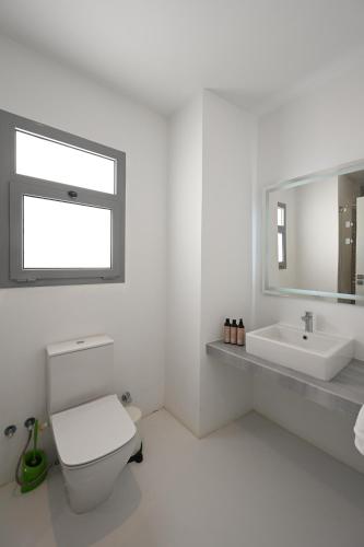 a white bathroom with a toilet and a sink at El Gouna - BIRD NEST in Hurghada