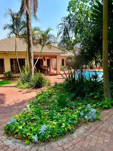 a house with a garden with plants in front of it at A boutique lodge situated in a serene environment - 2026 in Harare