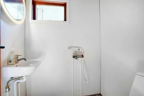 a white bathroom with a sink and a shower at Architectural Holiday Home By Sejerø Bay in Nykøbing Sjælland