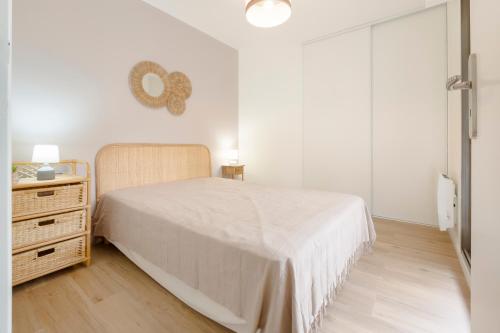 une chambre blanche avec un lit et une commode dans l'établissement La Baule, 3 pièces, Les Palmiers, à La Baule