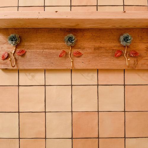 a wooden shelf with flowers on a tiled wall at Rustic Holiday Apartment, Lovingly Restored in Rambin