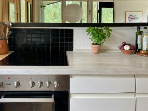 a kitchen with a counter top and a stove at Lovely House Near Nature And Beach in Tjørneholm