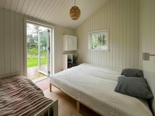 Un dormitorio con una cama grande y una ventana. en Idyllic View To The Fjord From Home, en Jægerspris