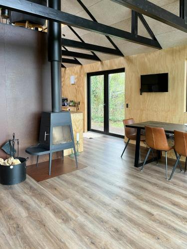 a living room with a table and a fireplace at Modern Wooden House Near Halkær Bredning in Nibe
