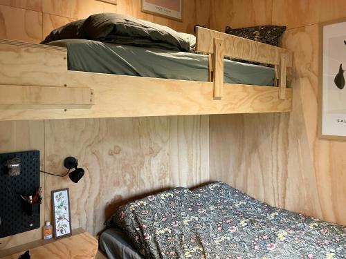 two bunk beds in a small room with a bed at Modern Wooden House Near Halkær Bredning in Nibe
