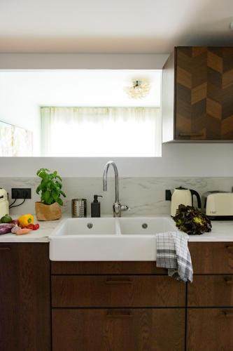 une cuisine avec un évier blanc et une fenêtre dans l'établissement Superbe appartement idéalement situé, à Aix-en-Provence