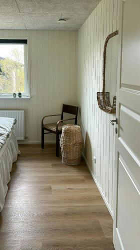 a room with a bed and a chair and a window at Modern Holiday Home Near Vesterløkken Beach in Tanderup