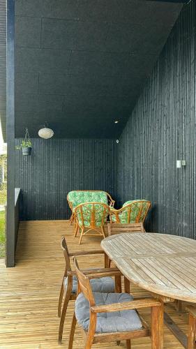 a dining room with a wooden table and chairs at Modern Holiday Home Near Vesterløkken Beach in Tanderup