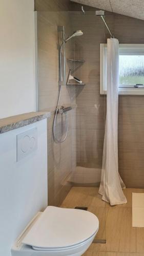 a bathroom with a toilet and a shower with a shower curtain at Holiday Home Idyll By Roskilde Fjord in Kirke-Hyllinge