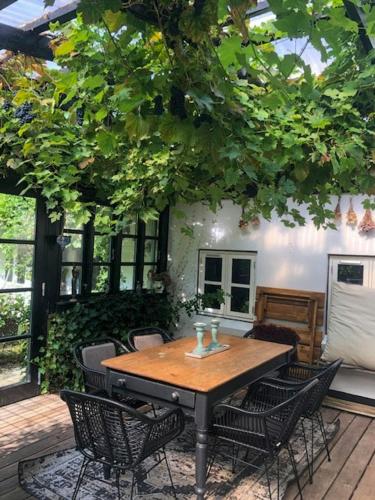 a wooden table and chairs on a patio at Country House With Large Garden On Langeland in Humble