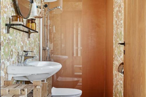 洛肯70'S Style Summerhouse Near Løkken的带水槽和马桶的浴室