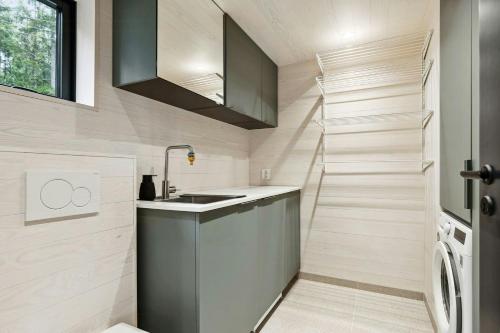 a small kitchen with a sink and a staircase at New Cabin By Tyrifjorden For Relaxing Holidays in Gjesval