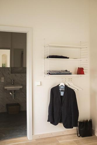a black jacket hanging on a wall in a bathroom at Holiday Apartment In Manor House On Rügen in Poseritz