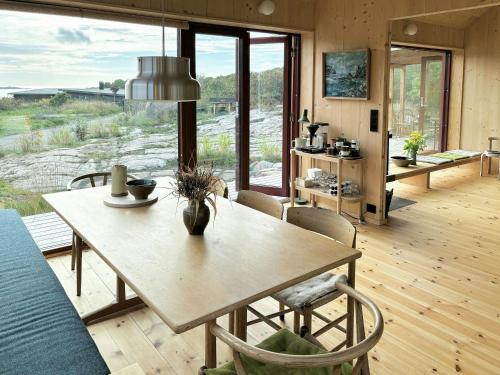a dining room with a table and chairs and a large window at Architect-Designed Cabin With Sea View In Loshavn in Farsund