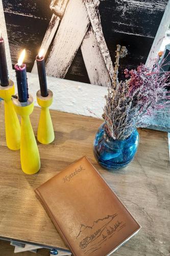 a table with three candles and a paper and a card at Cosy Cabin With Annex At Blefjell in Kongsberg