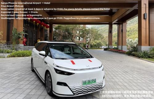 三亚三亚亚龙湾星华套房假日酒店的一辆白色汽车停在一栋建筑物前