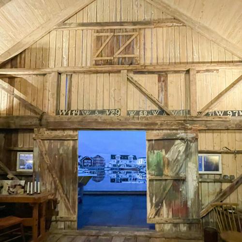 an inside view of a barn with a large window at Seaside Boathouse In Veiholmen in Smøla