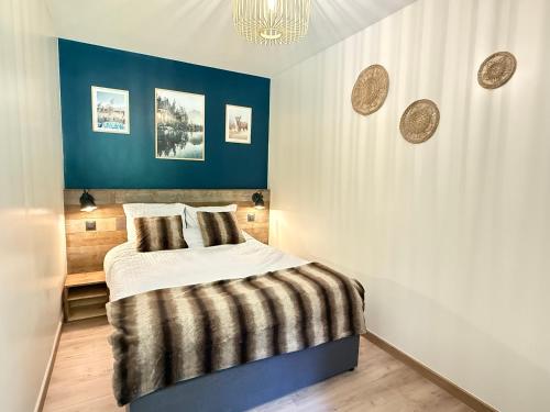 une chambre avec un lit et un mur bleu dans l'établissement Le Cocon du Lac, terrasse, vue lac, à Gérardmer