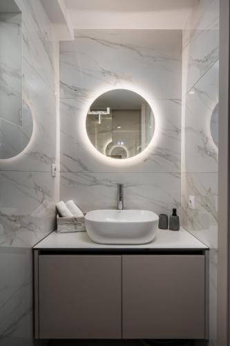 a white bathroom with a sink and a mirror at Old Town Elegant suite in Corfu