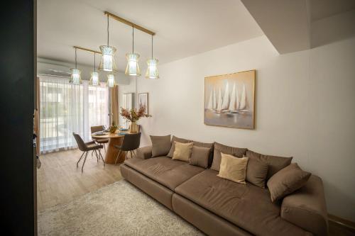 a living room with a brown couch and a table at Ambient in Infinity Pool & Spa Resort in Mamaia