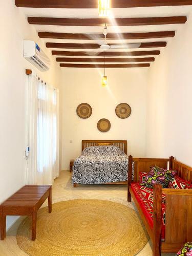 a bedroom with two beds and a coffered ceiling at Tulivu Zanzibar in Bwejuu