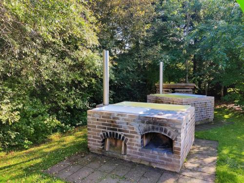 a brick oven sitting in the grass in a yard at Home Near Beach With Wilderness Bath in Sindrup