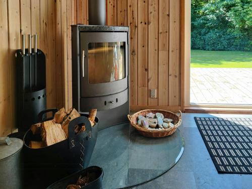 a room with a glass table with a stove at Home Near Beach With Wilderness Bath in Sindrup