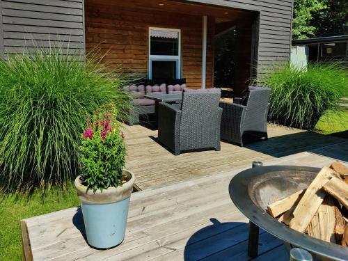 a patio with chairs and a potted plant on a deck at Home Near Beach With Wilderness Bath in Sindrup