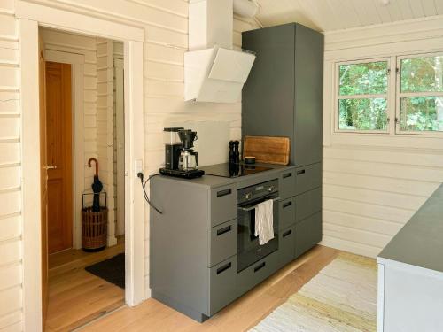 a kitchen with a stove top oven next to a window at Summerhouse In Forest Near Rørvig Beach in Nykøbing Sjælland