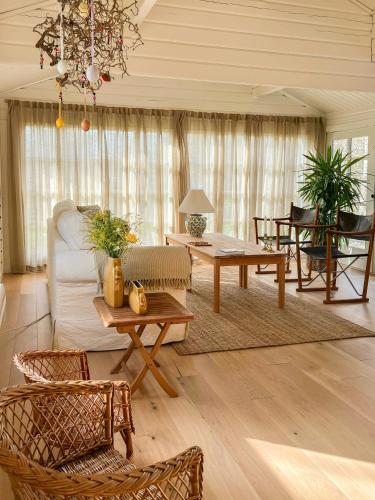 a living room with a couch and tables and chairs at Summerhouse In Forest Near Rørvig Beach in Nykøbing Sjælland