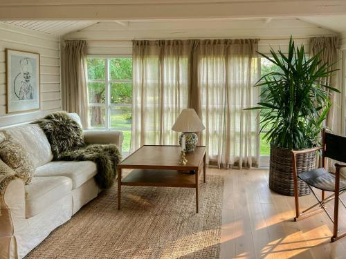 a living room with a couch and a coffee table at Summerhouse In Forest Near Rørvig Beach in Nykøbing Sjælland