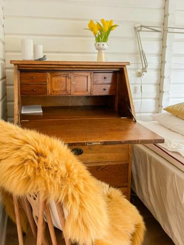 a wooden desk with a vase of flowers on top at Summerhouse In Forest Near Rørvig Beach in Nykøbing Sjælland