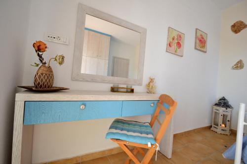 a dressing table with a mirror and a wooden chair at Kathara Bay Apartments in Faliraki