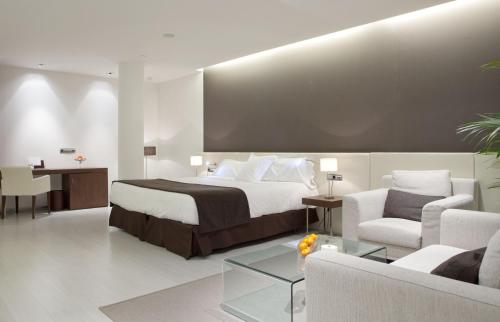 a hotel room with a bed and a table and chairs at Hotel Diagonal Plaza in Zaragoza