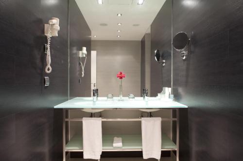 a bathroom with a sink and a mirror at Hotel Diagonal Plaza in Zaragoza
