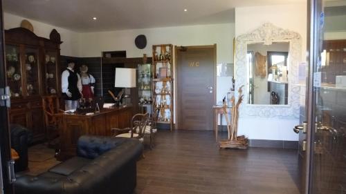 a living room with a leather couch and a table at Hotel Rurale Orti di Nora & SPA in Santa Margherita di Pula