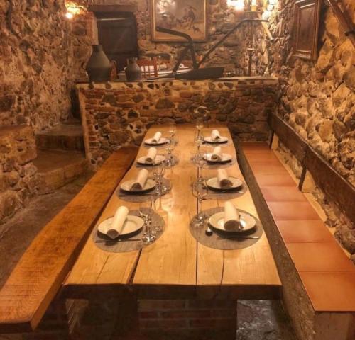 a long wooden table with glasses and plates on it at Can Masferrer in Riudarenes