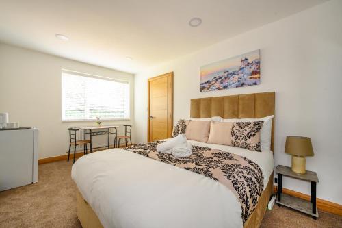 a bedroom with a large bed and a table at -RD7B- For your relaxed and Cosy stay with Free WiFi in Batley