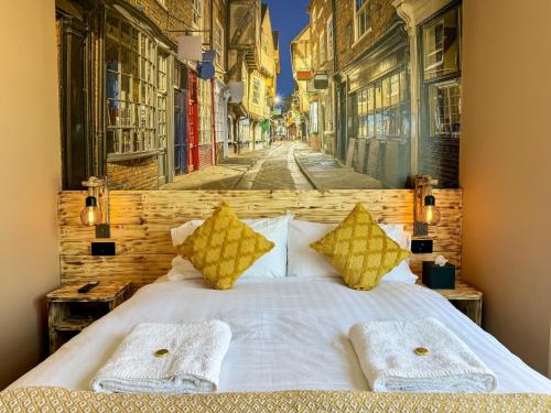a white bed with yellow pillows on a street at The Crescent York in York