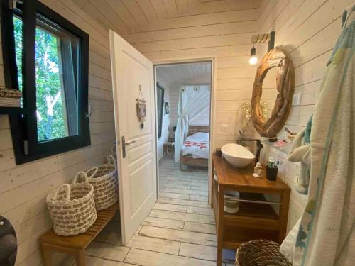 une salle de bain avec un lavabo et un miroir dans l'établissement Chalet surplombant la pinède à 2Km de l'ocean, à Lacanau