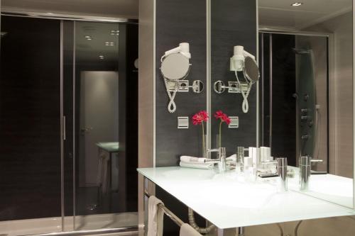 a bathroom with two sinks and a large mirror at Hotel Diagonal Plaza in Zaragoza