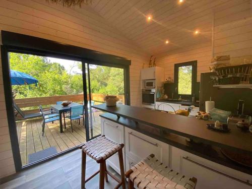 - une cuisine avec vue sur une terrasse dotée d'une table dans l'établissement Chalet surplombant la pinède à 2Km de l'ocean, à Lacanau