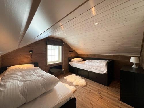 two beds in a room with wooden walls at Mountain Cabin With Panoramic View In Nesbyen in Nesbyen