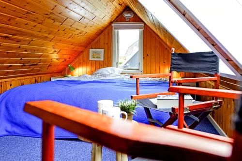 a bedroom with a bed and a chair in a attic at Sleep Under The Stars Near Brunsnæs Beach in Broager