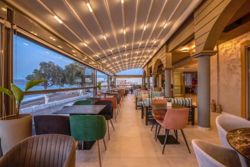 a restaurant with tables and chairs and a large window at Christina Beach Hotel in Kissamos