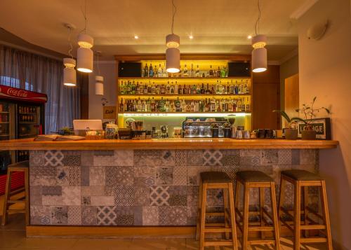 a bar with stools in a room with a counter at Christina Beach Hotel in Kissamos