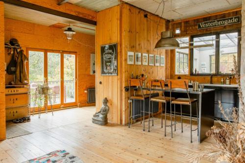 a kitchen with wooden walls and a counter with stools at Restored Quarry House Near Nobel Laureate Home in Lönsboda