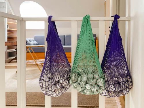 two bags hanging from a rail in a living room at Timber House With View On Samsø in Nordby