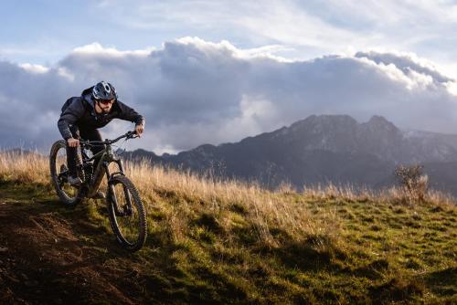 a man riding a bike on a grassy hill at Hotel ZAWRAT Ski Resort & Spa in Białka Tatrzanska