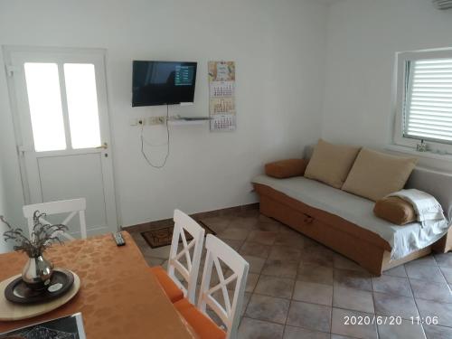 salon z kanapą i stołem w obiekcie Apartmani Lucia Biograd w Biogradzie na Moru
